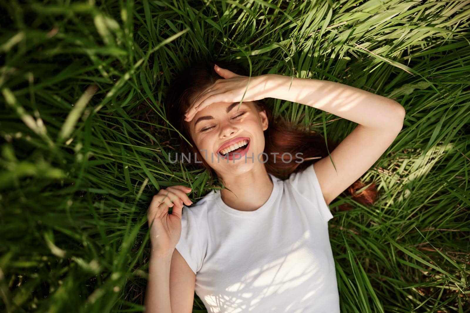 portrait of smiling happy woman with teeth on the grass. High quality photo