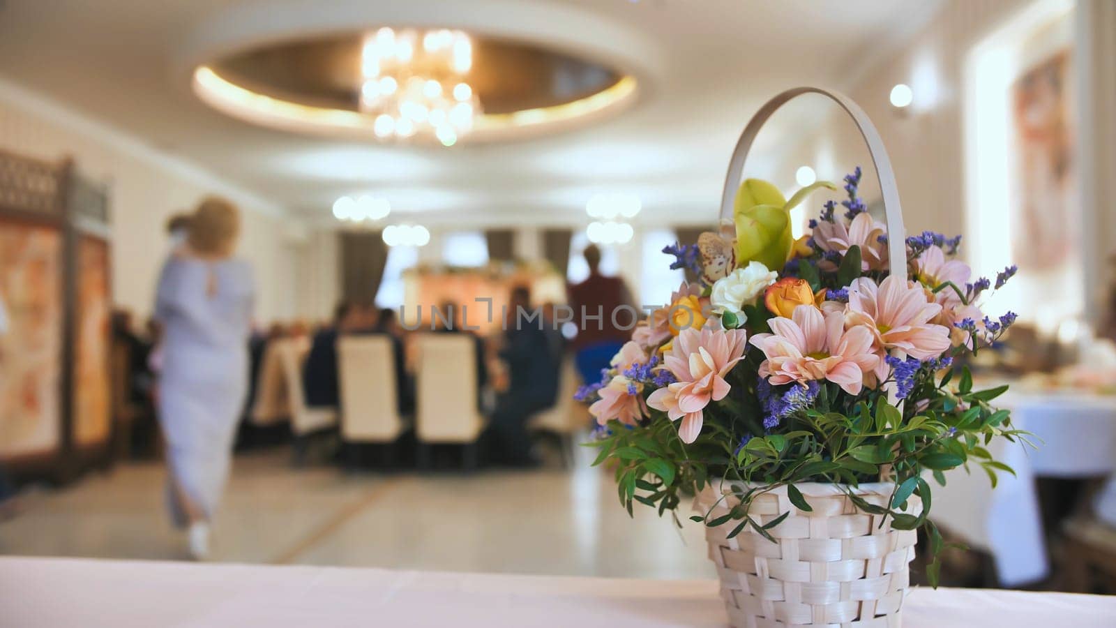 Wedding celebration background concept. A bouquet of flowers on the background of the banquet guests who are eating