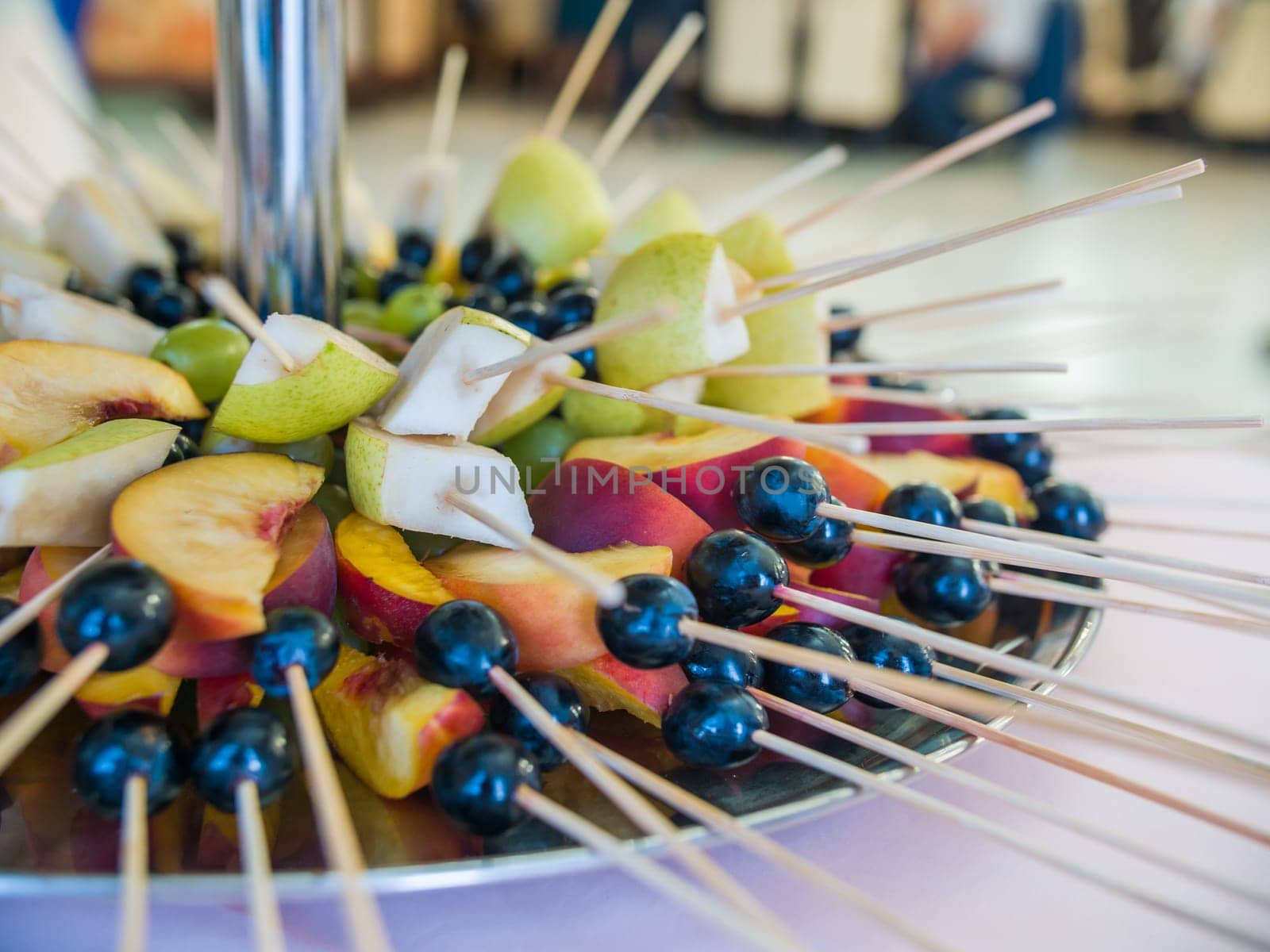 Fruit on a stick at a wedding celebration with light illumination