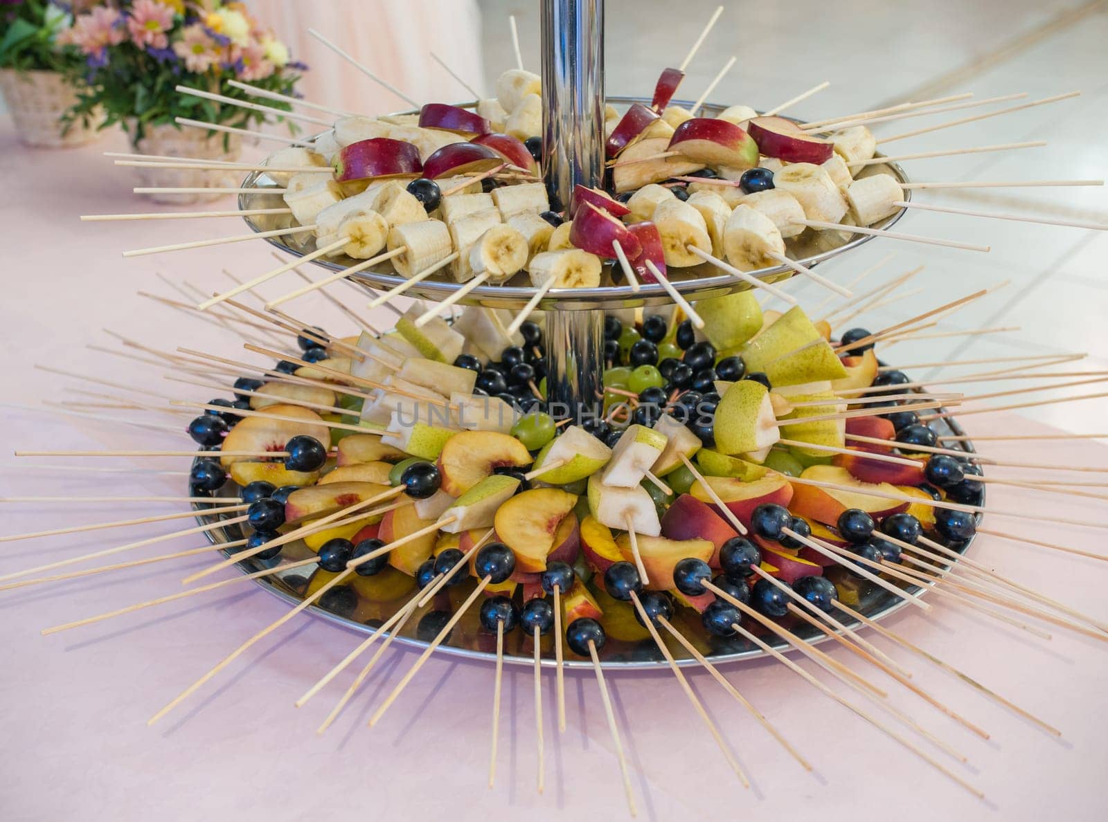 Fruit on a stick at a wedding celebration with light illumination