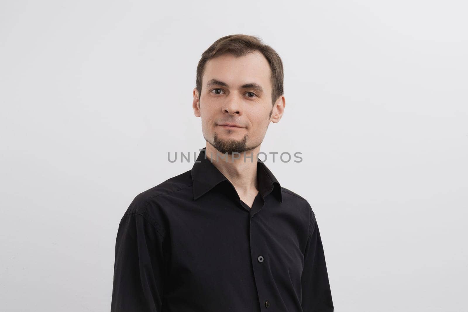 Just a portrait of caucasian man in his 30s with a beard and in a black shirt on a white background.