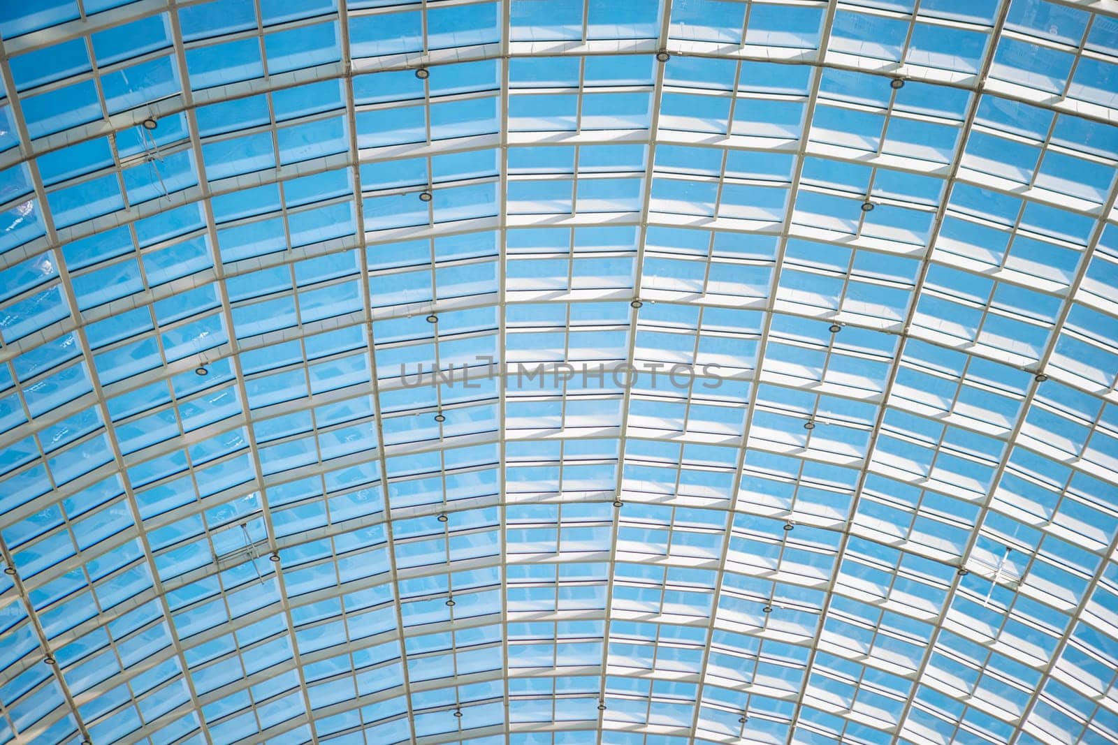 a huge transparent dome-shaped glass ceiling. view of the blue summer sky.