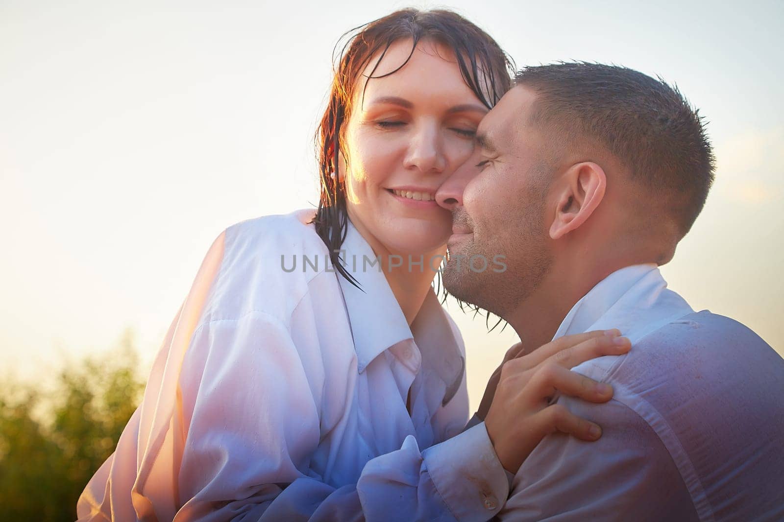 Wet happy Couple Outdoor relaxin, having fun and hugs on nature in the park in summer day with smog and fog. Family or lovers have date and rest outdoors. Concept of love and friendship by keleny