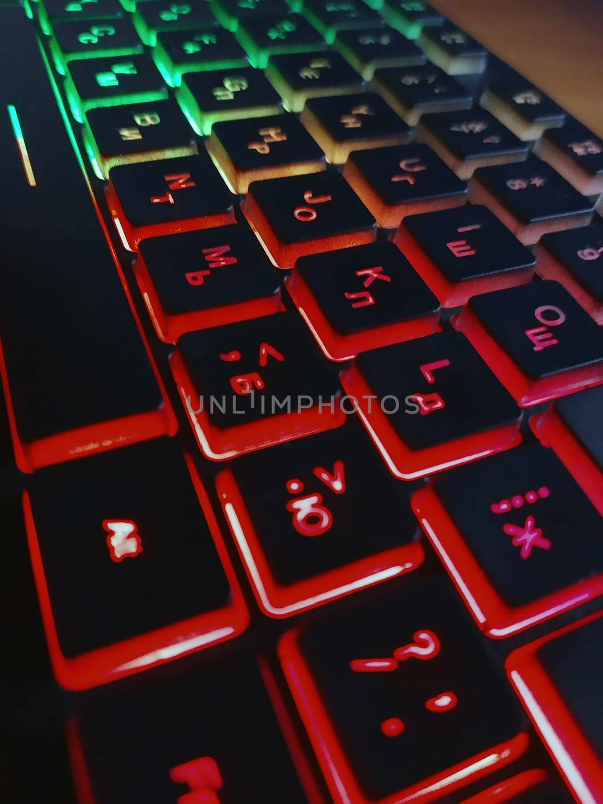 Bright multicolored backlit computer keyboard close-up on the table. Computer keyboard.