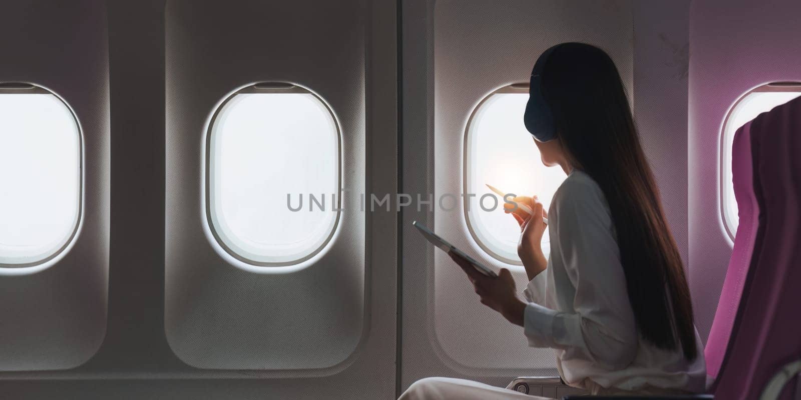 Beautiful Asian businesswoman working with digital tablet in aeroplane. working, travel, business concept.