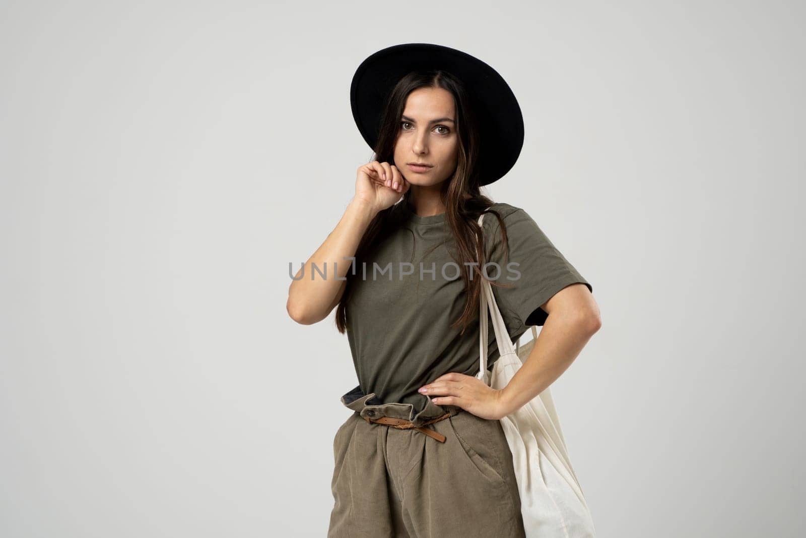 Young woman in a green t-shirt and black hat with white cotton bag