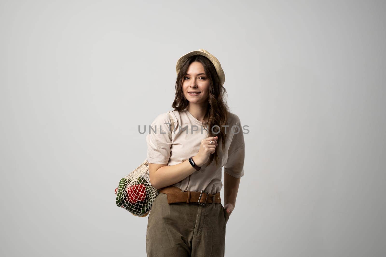 Zero waste concept. Young woman holding reusable cotton shopping mesh bag with groceries from a market. Concept of no plastic. Zero waste, plastic free. Eco friendly concept. Sustainable lifestyle. by vovsht