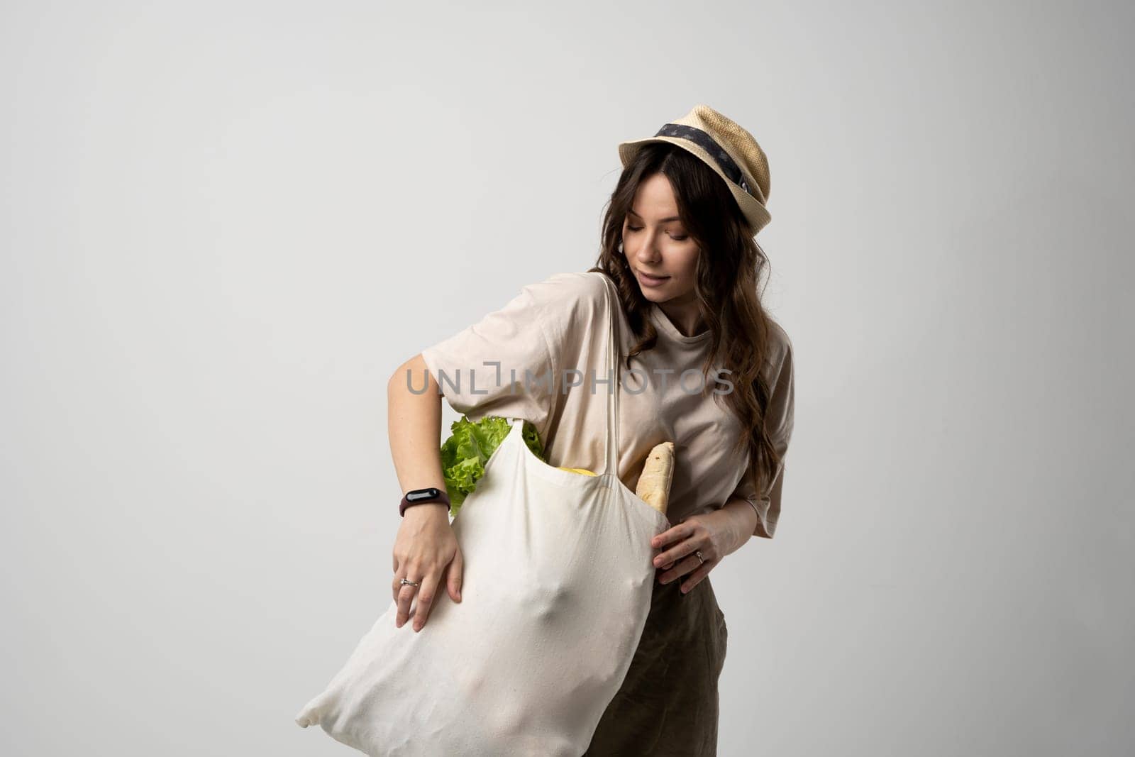 Zero waste concept. Woman holding reusable cotton shopping bag with groceries. Plastic free. Eco friendly concept. Sustainable lifestyle