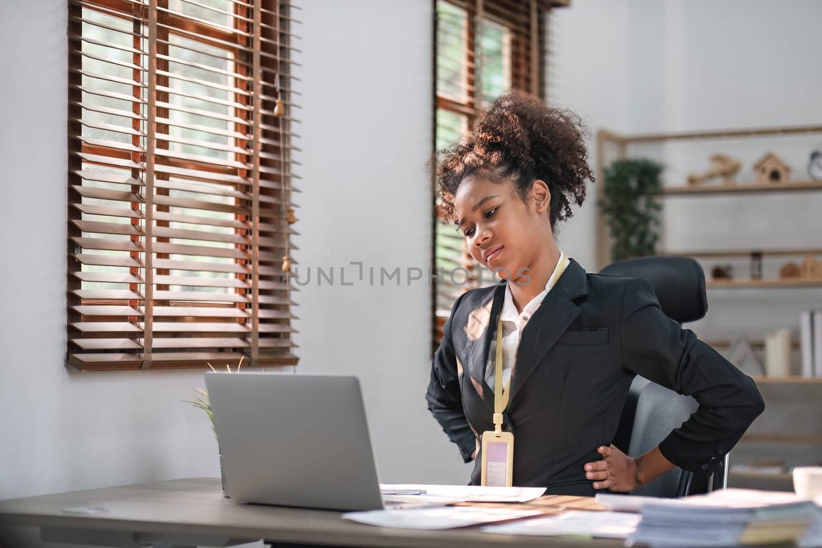 tired business woman sleepy and bored from sitting at a desk for a long time and has office syndrome..