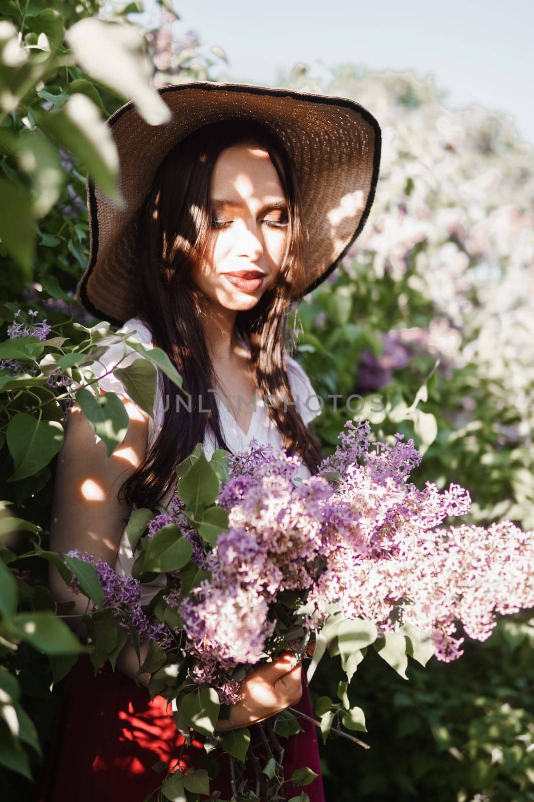 A fashionable girl with dark hair, a spring portrait in lilac tones in summer. Bright professional makeup