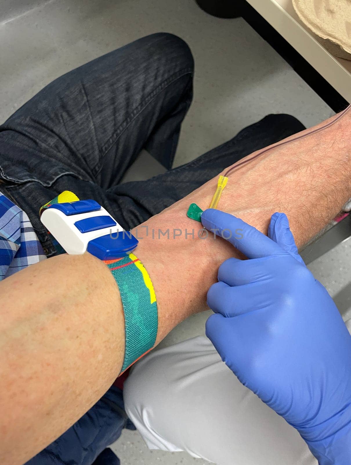 a nurse, doctor or medical technologist in blue gloves taking a blood sample from a patient in a hospital. High quality photo