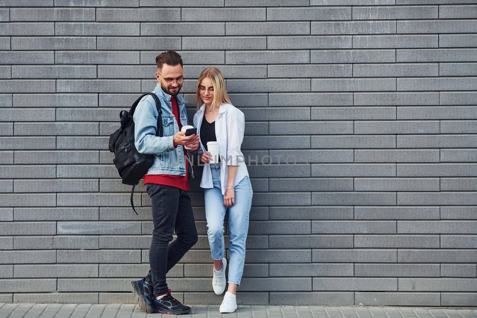 Young stylish man with woman in casual clothes outdoors together. Conception of friendship or relationships.