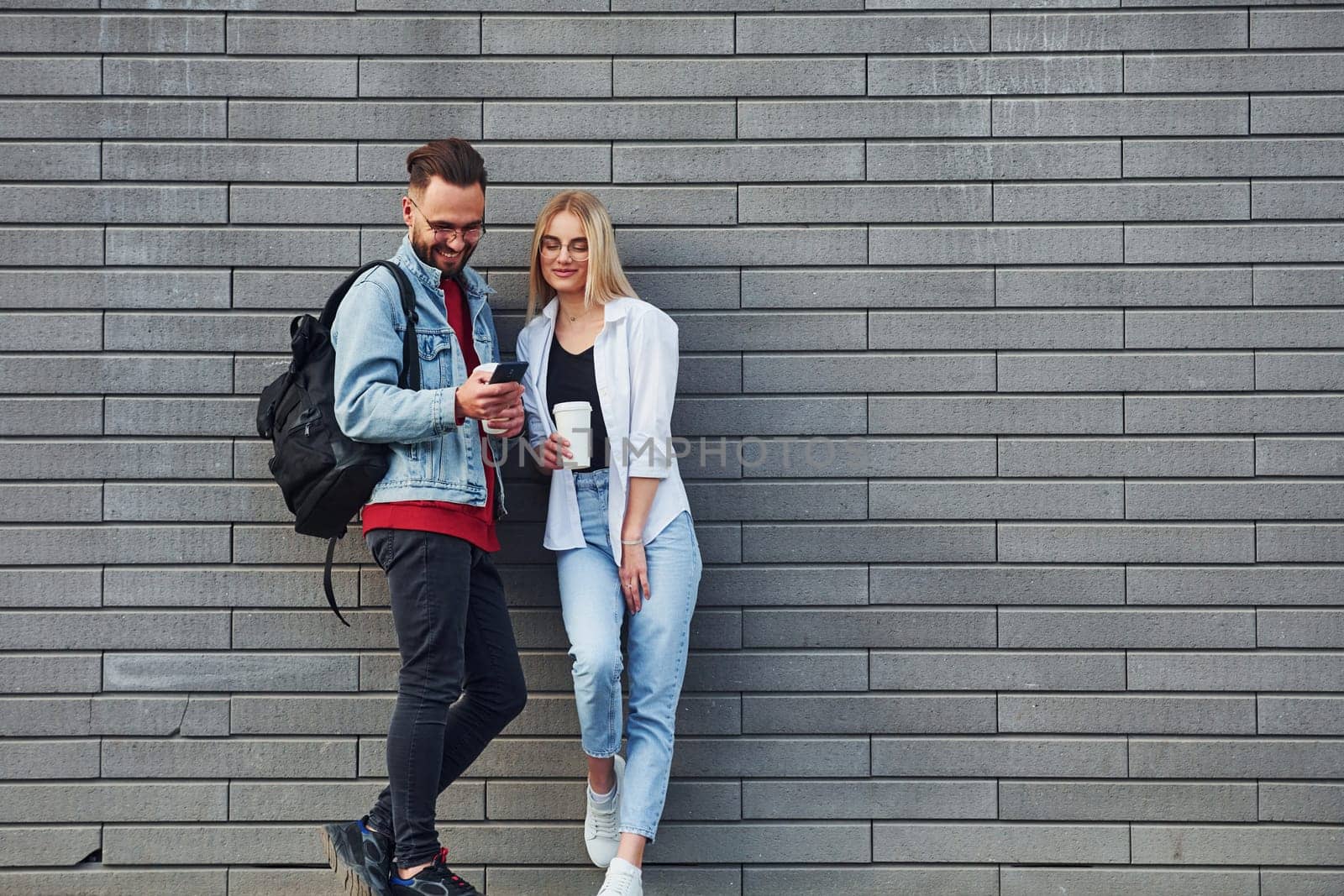 Young stylish man with woman in casual clothes outdoors together. Conception of friendship or relationships.