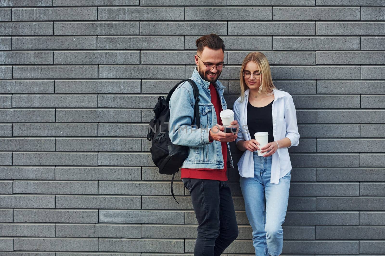 Young stylish man with woman in casual clothes outdoors together. Conception of friendship or relationships.