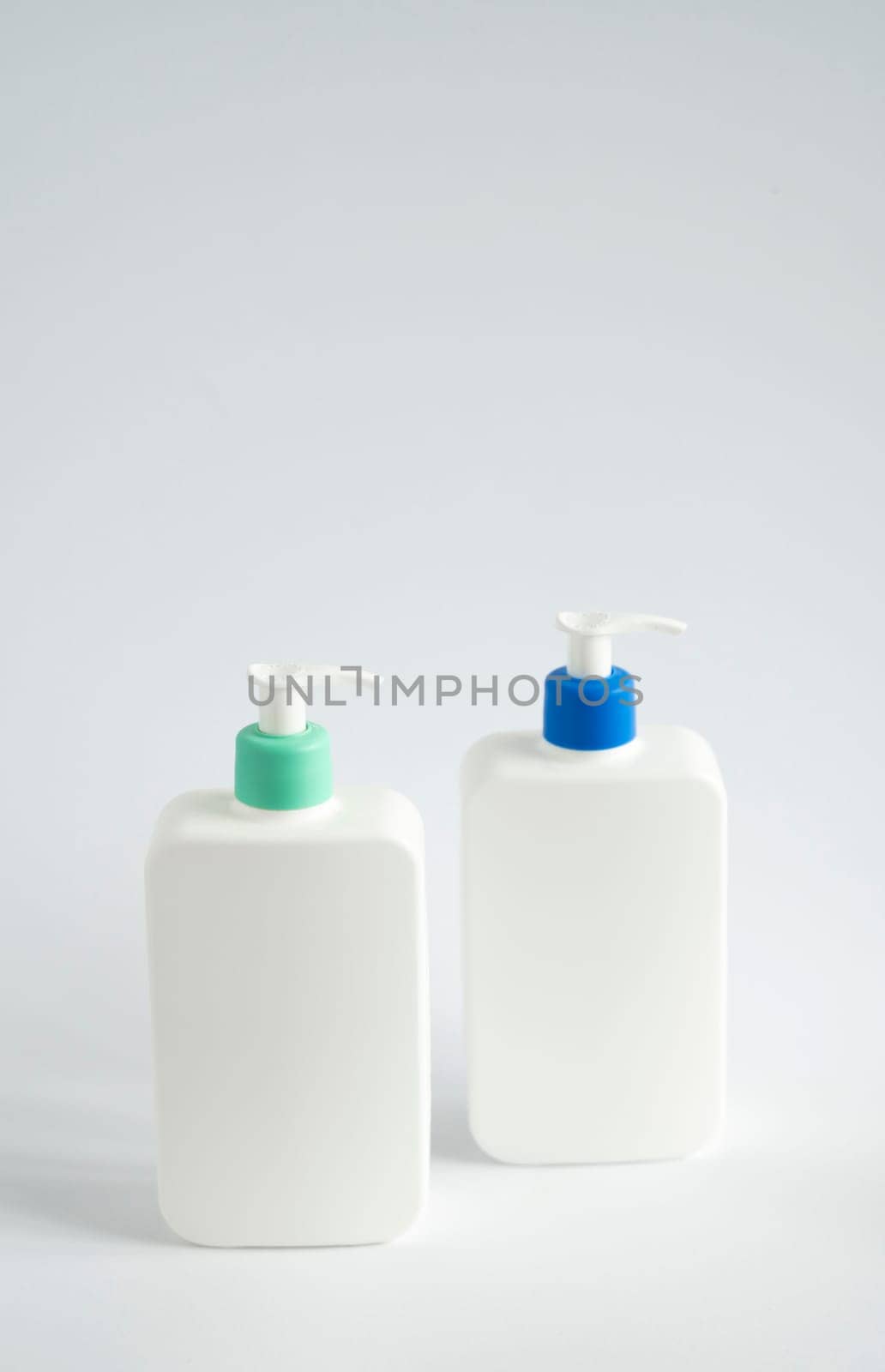 Two liquid containers for shampoo, gel, lotion, cream, bath foam etc. Blank unbranded cosmetic plastic bottles with dispenser pump