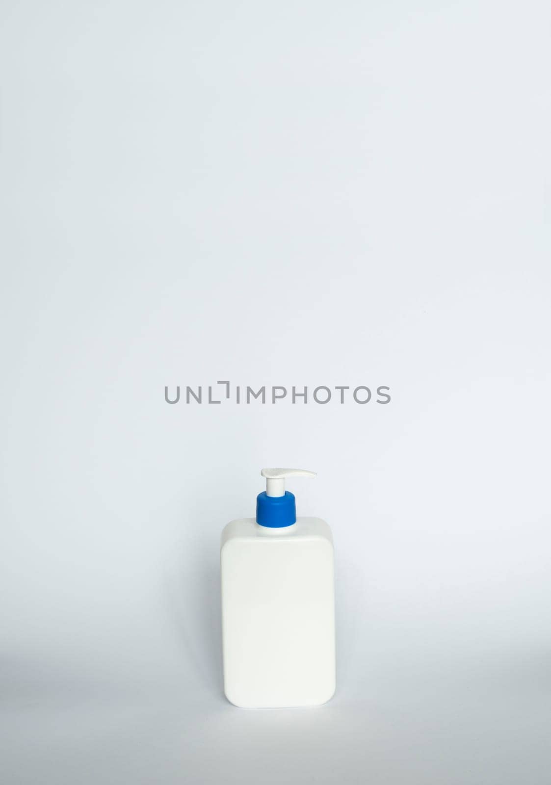 White unbranded bottle with a black dispenser isolated on white background. cosmetic packaging mockup with copy space. Bottle for a shower, gel, soap