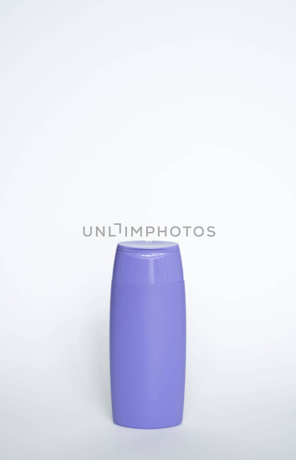 Violet plastic bottle of body care and beauty products. Studio photography of plastic bottle for shampoo, shower gel, creme isolated on white background. by vovsht