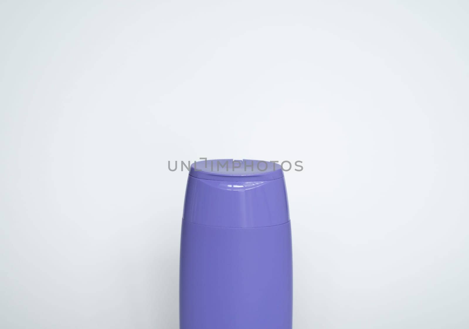 Violet plastic bottle of body care and beauty products. Studio photography of plastic bottle for shampoo, shower gel, creme isolated on white background