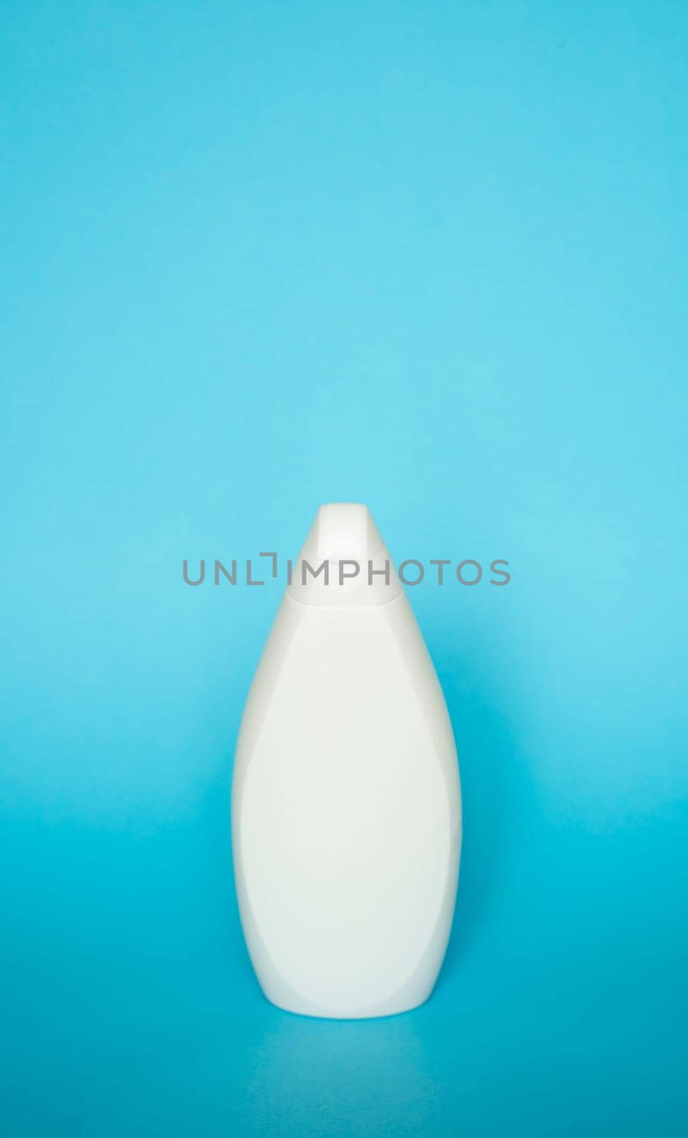 White plastic soap or shampoo bottle isolated on blue background. Skin care lotion. Bathing essential product. Shampoo bottle. Bath and body lotion. Fine liquid hand wash. Bathroom accessories