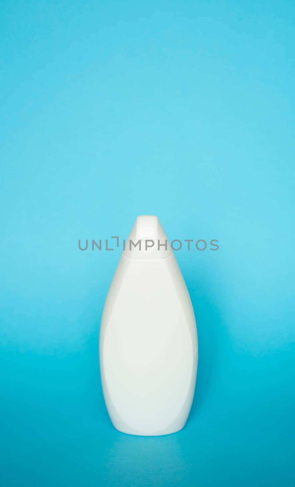 White plastic soap or shampoo bottle isolated on blue background. Skin care lotion. Bathing essential product. Shampoo bottle. Bath and body lotion. Fine liquid hand wash. Bathroom accessories. by vovsht