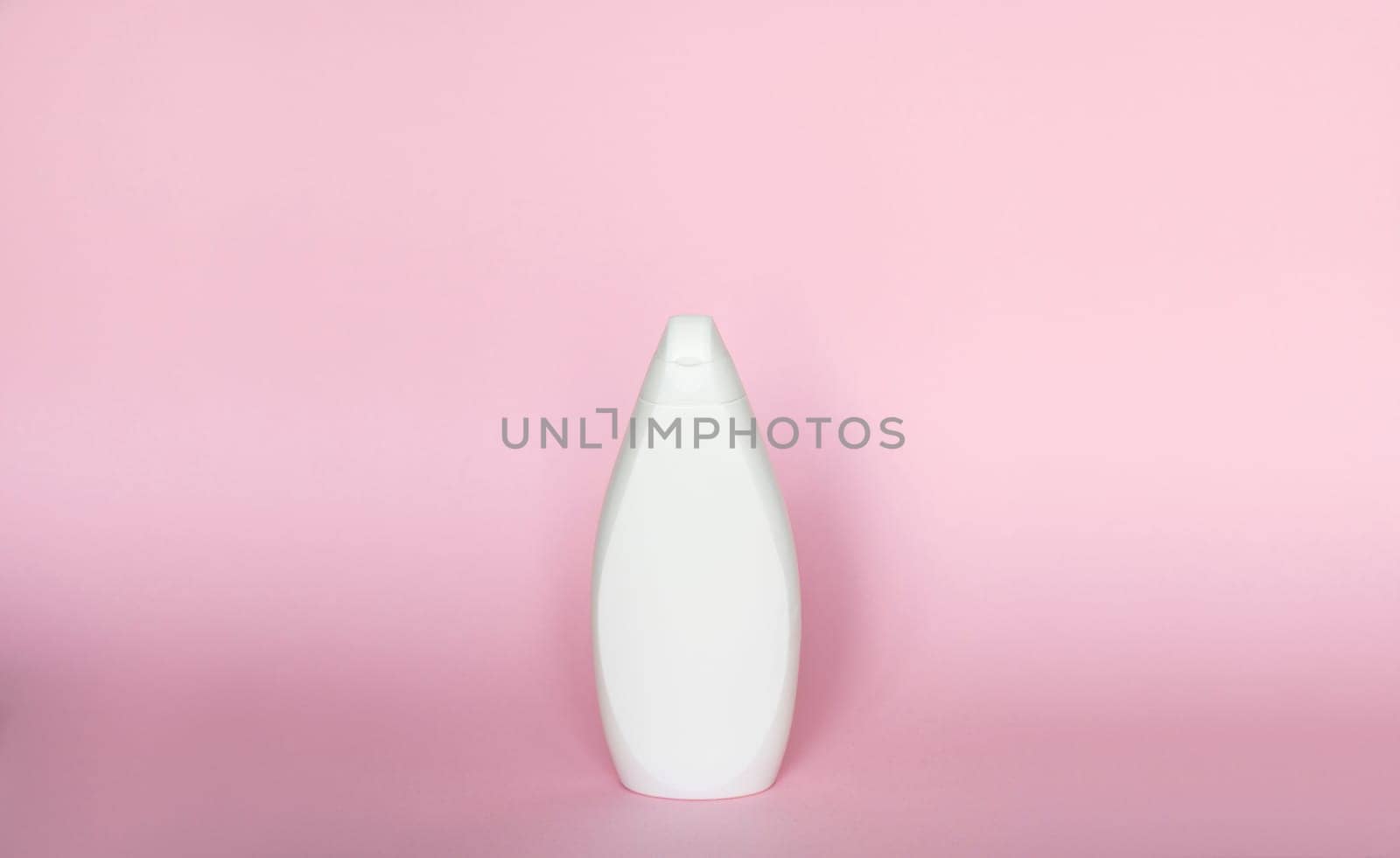 White bottle for liquid soap, shampoo, gel on pink background