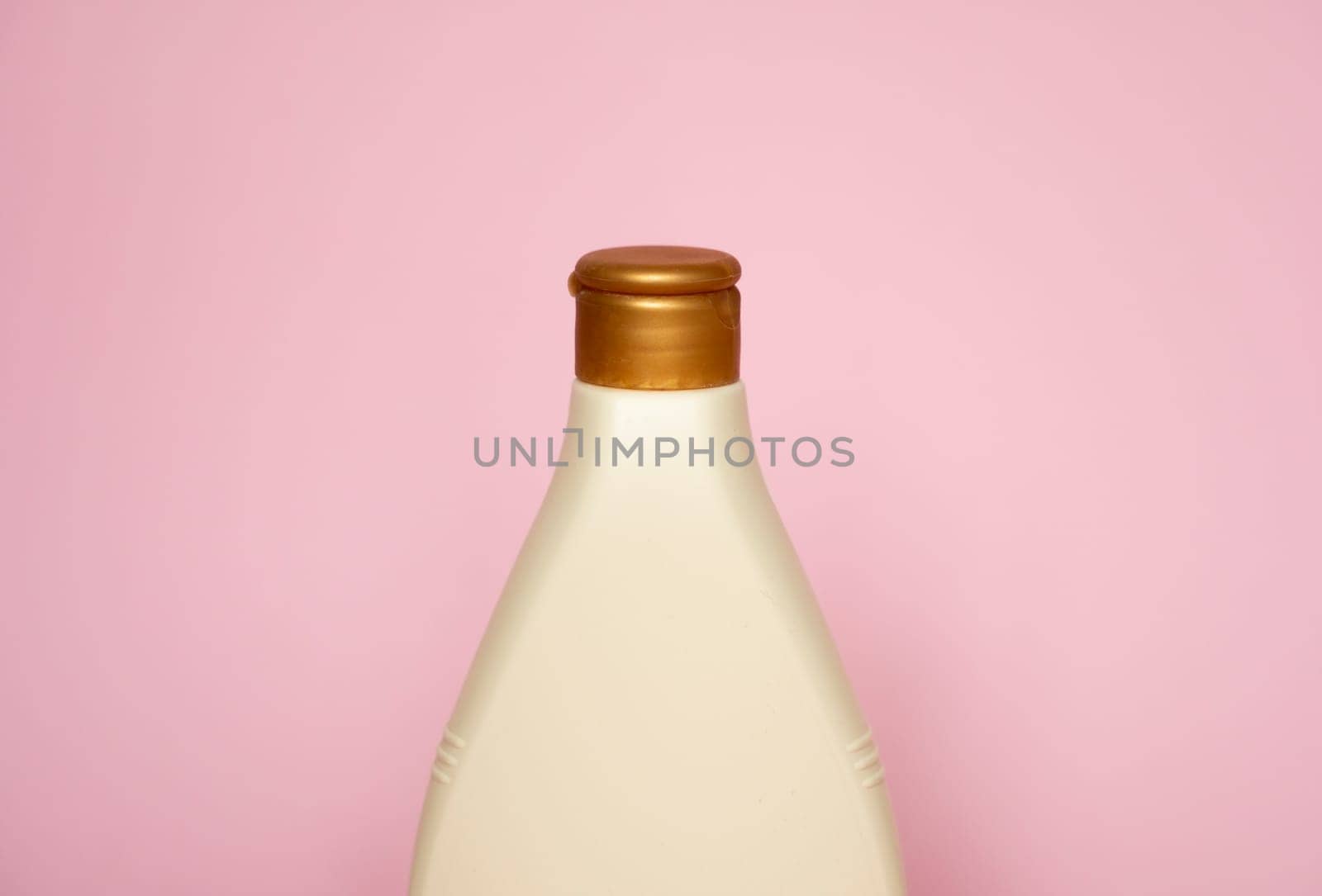 Beige plastic soap or shampoo bottle isolated on pink background. Skin care lotion. Bathing essential product. Shampoo bottle. Bath and body lotion. Fine liquid hand wash. Bathroom accessories