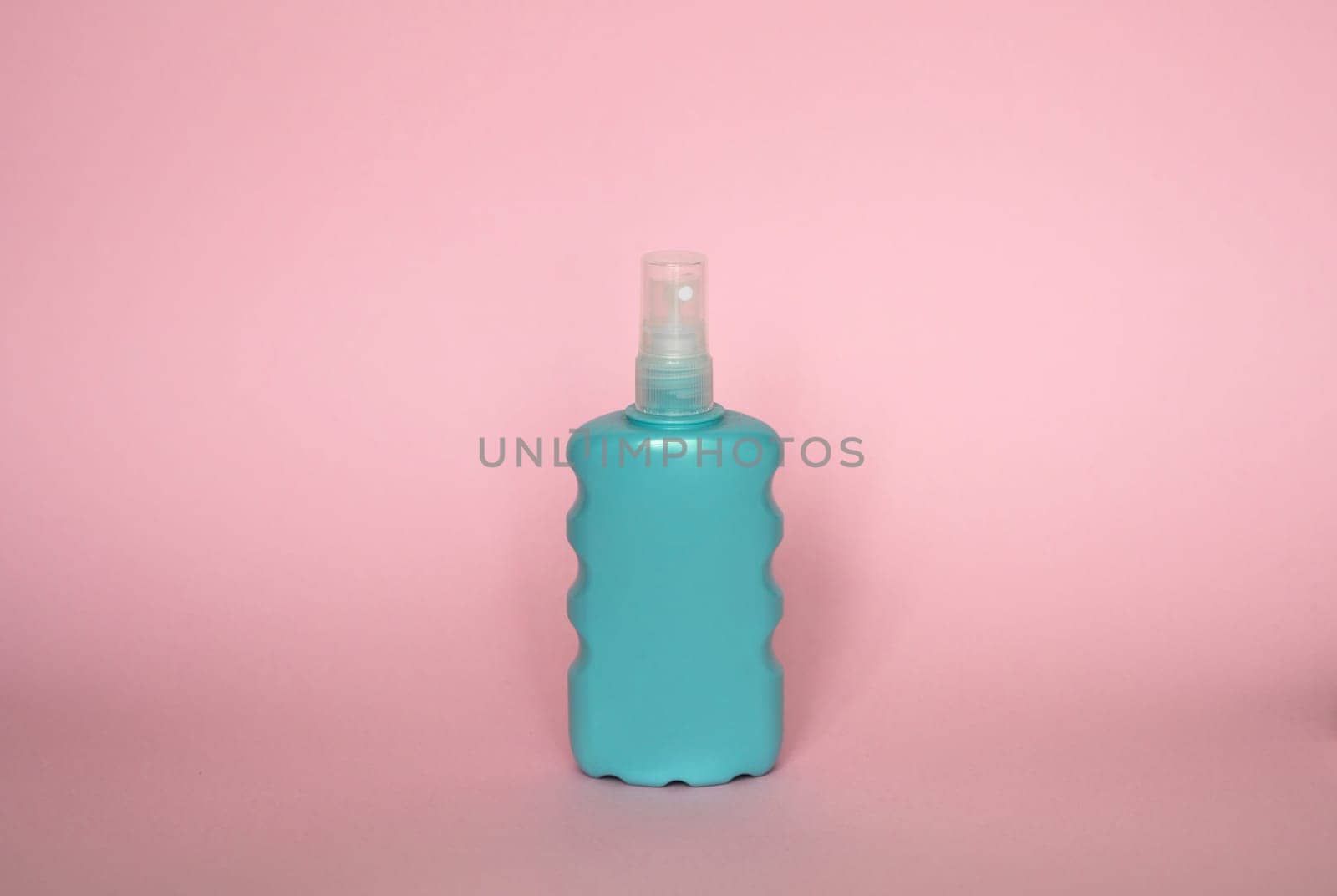 Blue blank unbranded cosmetic plastic bottle for shampoo, gel, lotion, cream, bath foam pink background