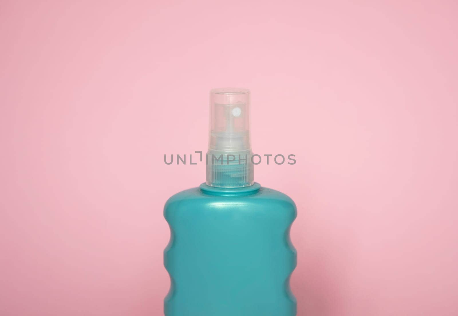 Blue blank unbranded cosmetic plastic bottle for shampoo, gel, lotion, cream, bath foam pink background