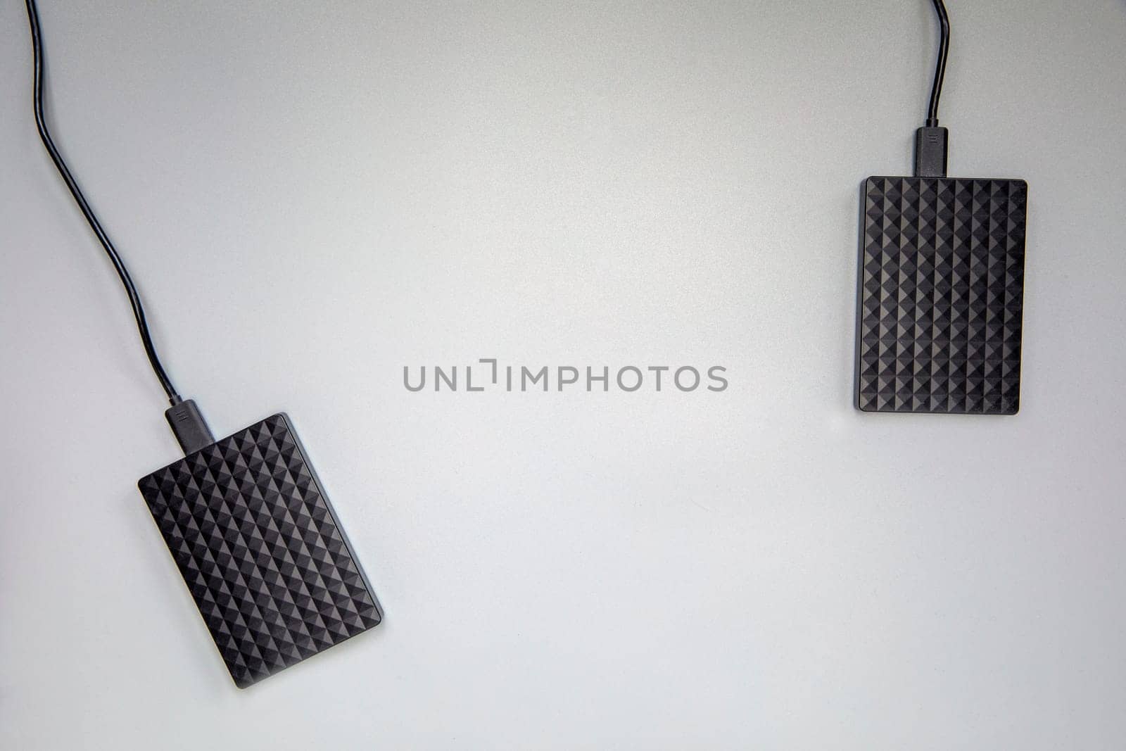 Portable black Hard Drive HDD isolated on grey background. Cool flat lay top view, copy space. Data storage concept for computers laptops,technology space for text