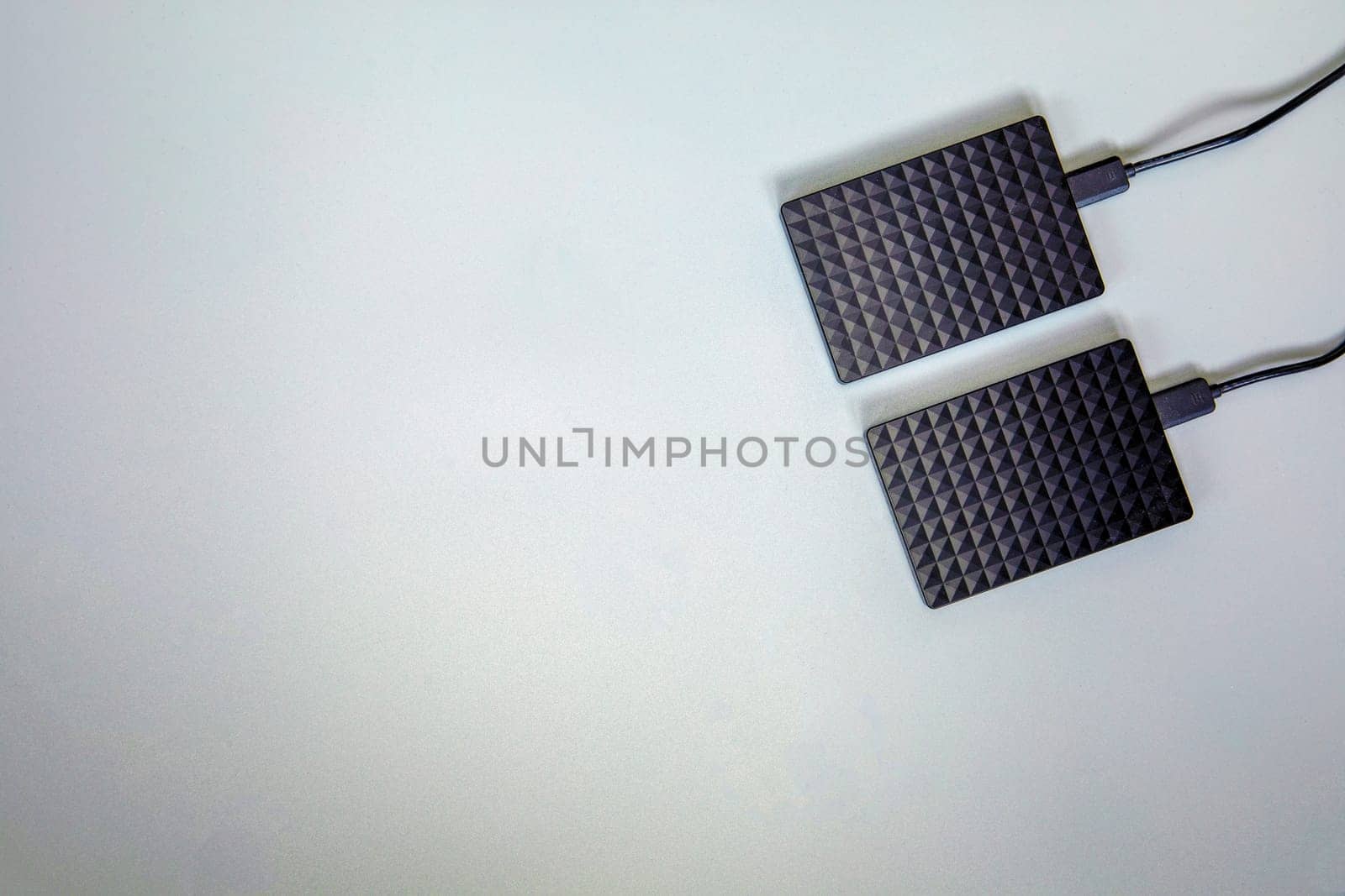 Portable black Hard Drive HDD isolated on grey background. Cool flat lay top view, copy space. Data storage concept for computers laptops,technology space for text