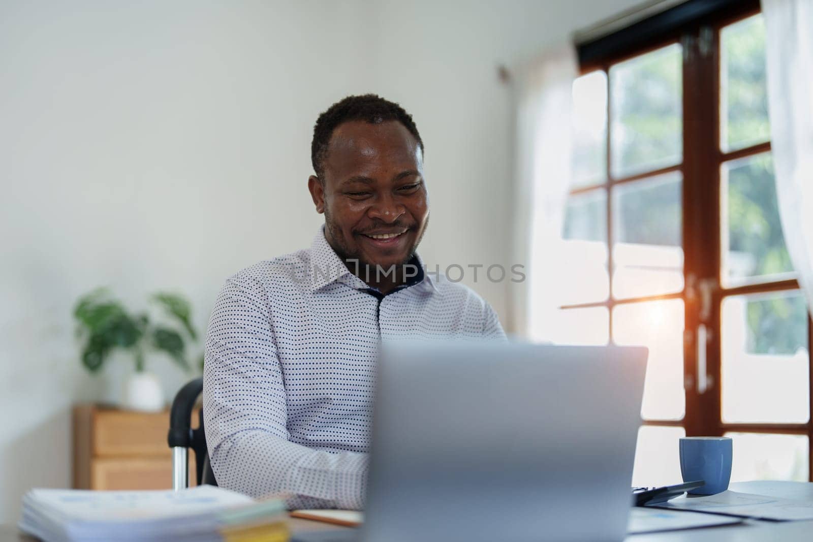 middle aged man American African using computer laptop with planning working on financial document, tax, exchange, accounting and Financial advisor.