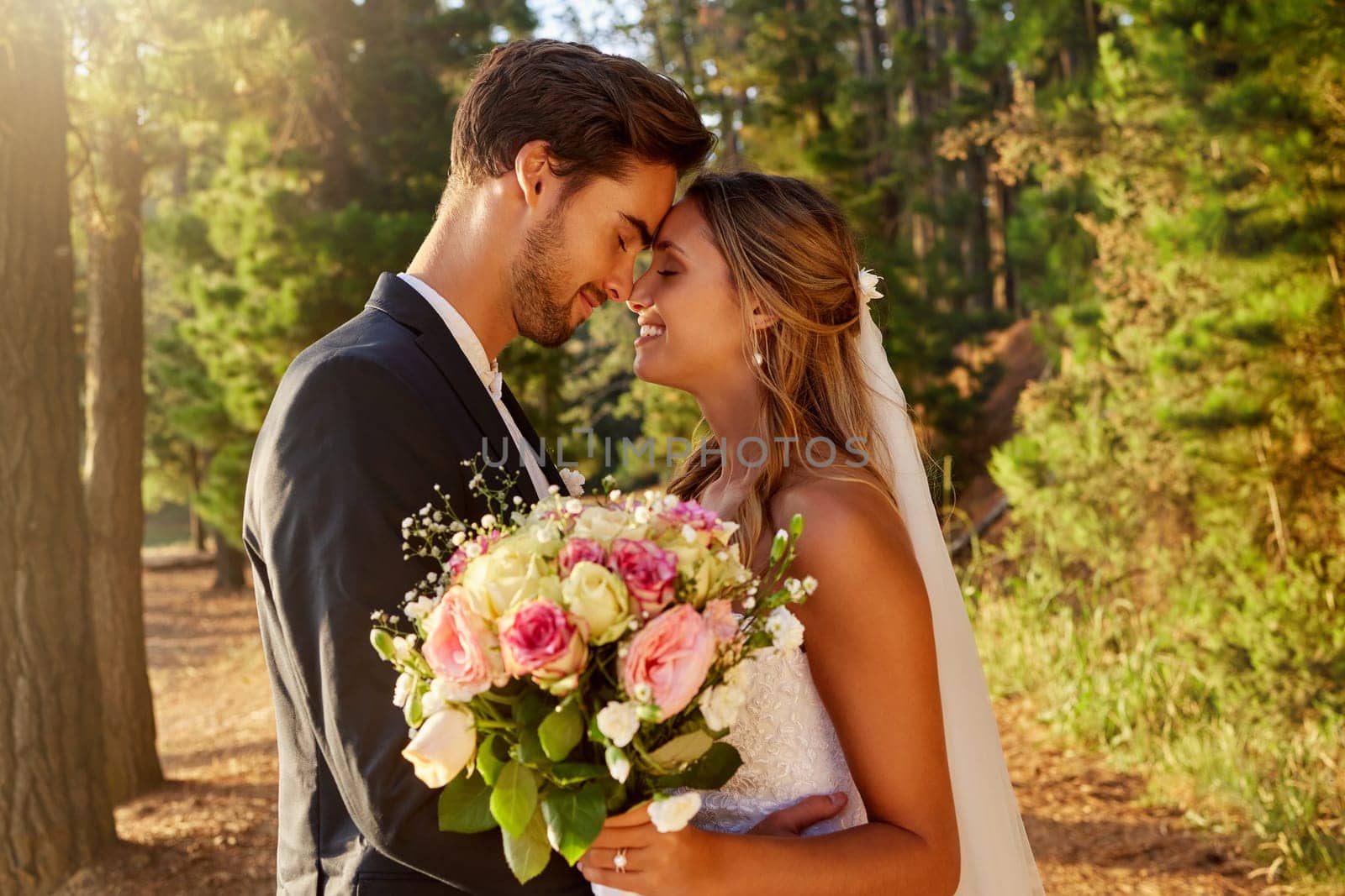 Wedding, kiss and love with couple in nature for celebration, marriage and ceremony. Happiness, affectionate and romance with man and woman in forest with bouquet for elegant, relationship and hug.