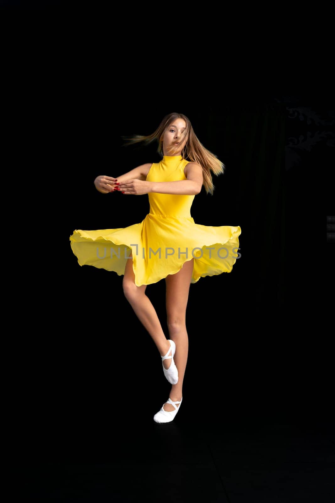 portrait of a teenage ballerina in a yellow suit on a black background by Edophoto