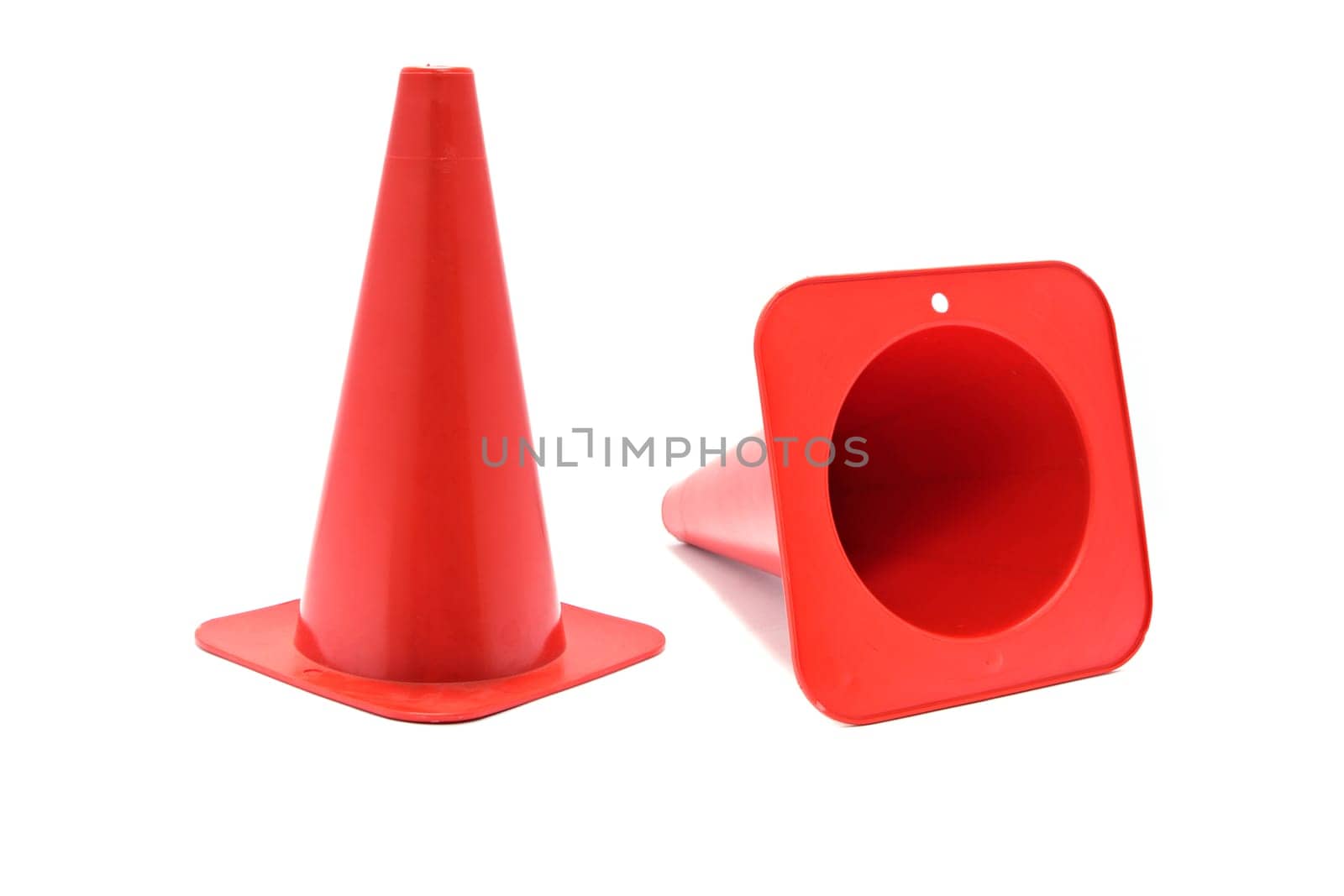 Red plastic cone with reflective stripes isolated on white background. Road cone signal
