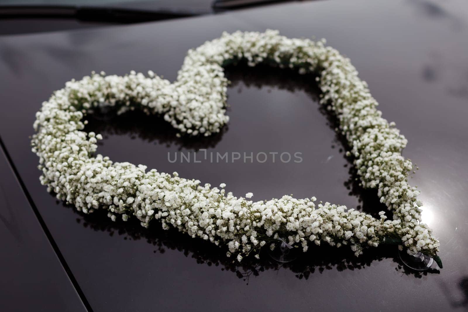 wedding car decorated with a heart of the white flowers. by Andriimedvediuk