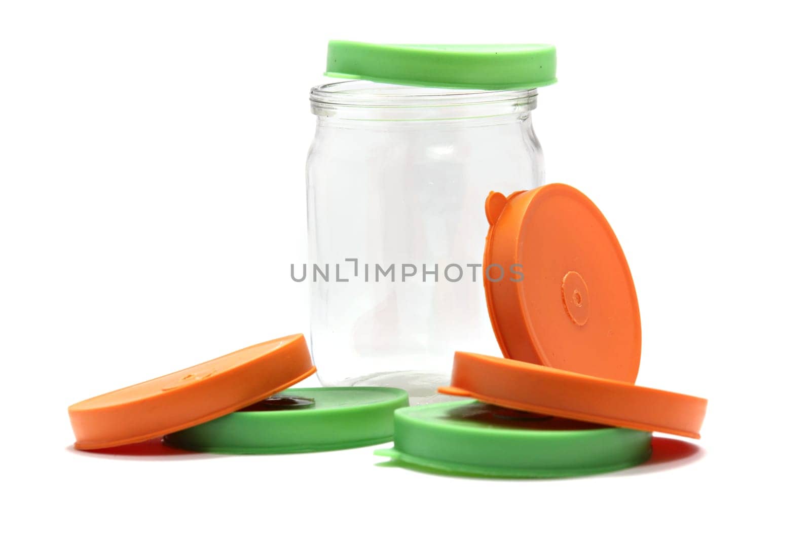 a glass of a pot with cover, orange, green cover. empty glass jar isolated on white with clipping path