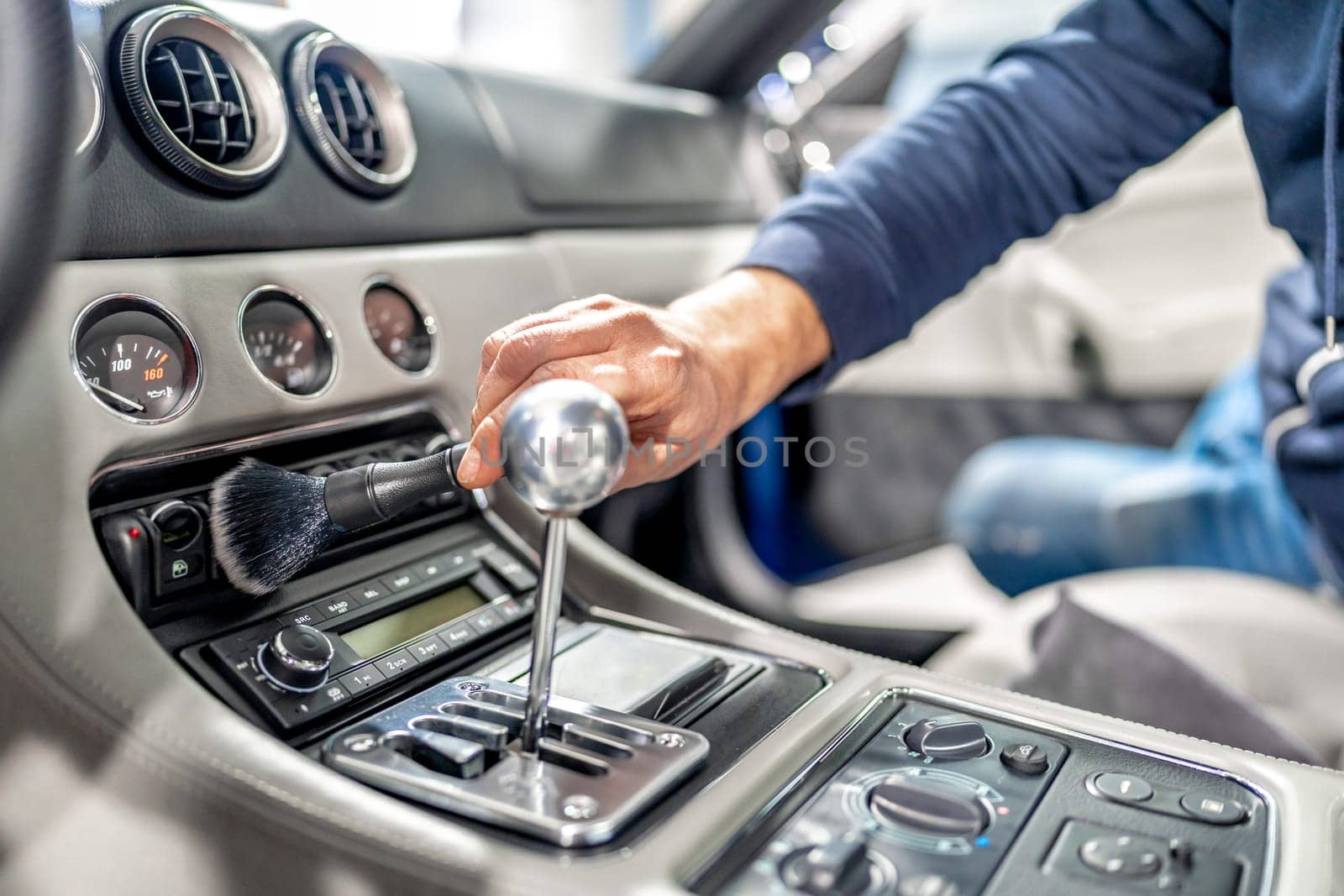 cleaning the interior of a luxury car with a brush. High quality photo