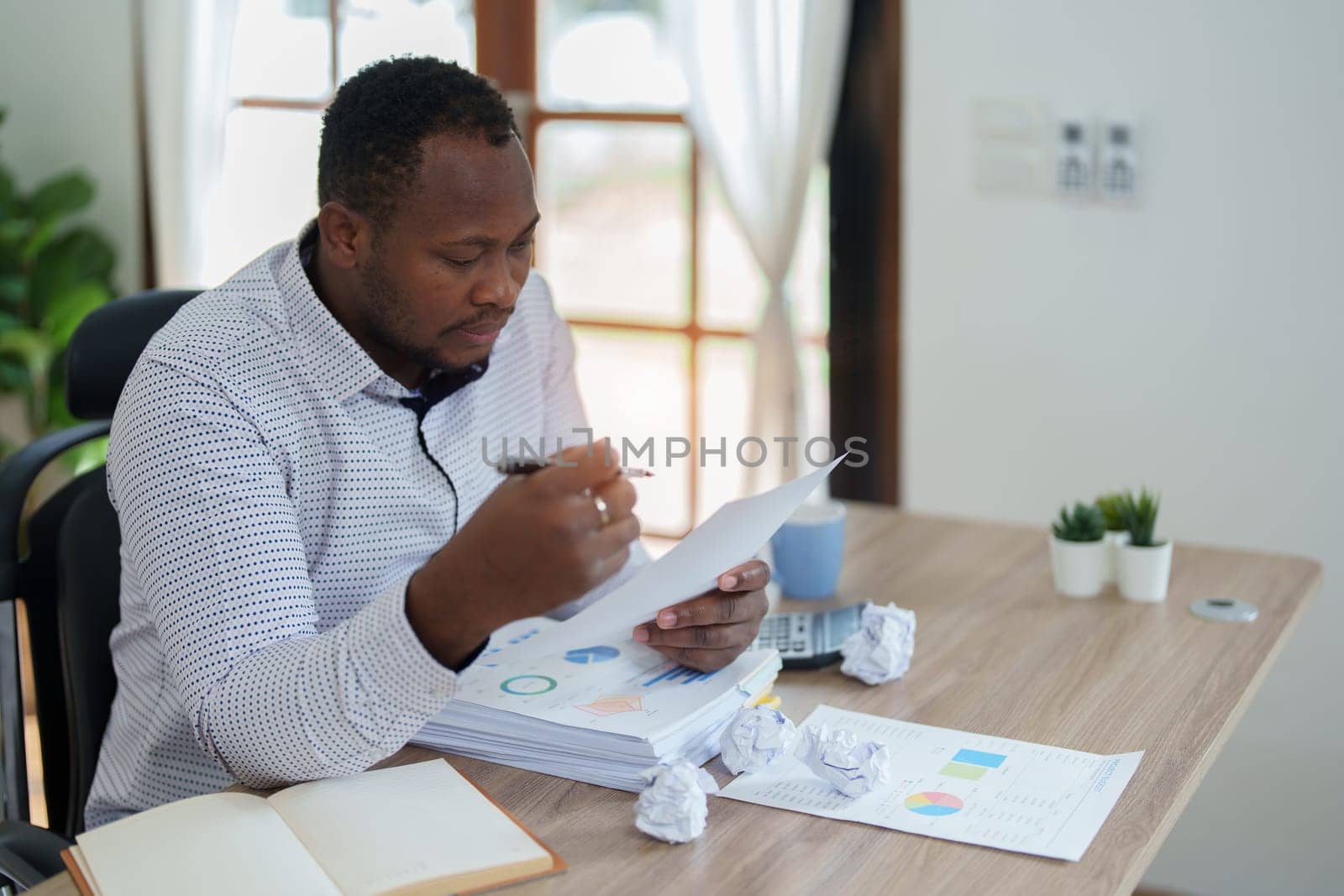 middle aged man American African using computer laptop with planning working on financial document, tax, exchange, accounting and Financial advisor by Manastrong