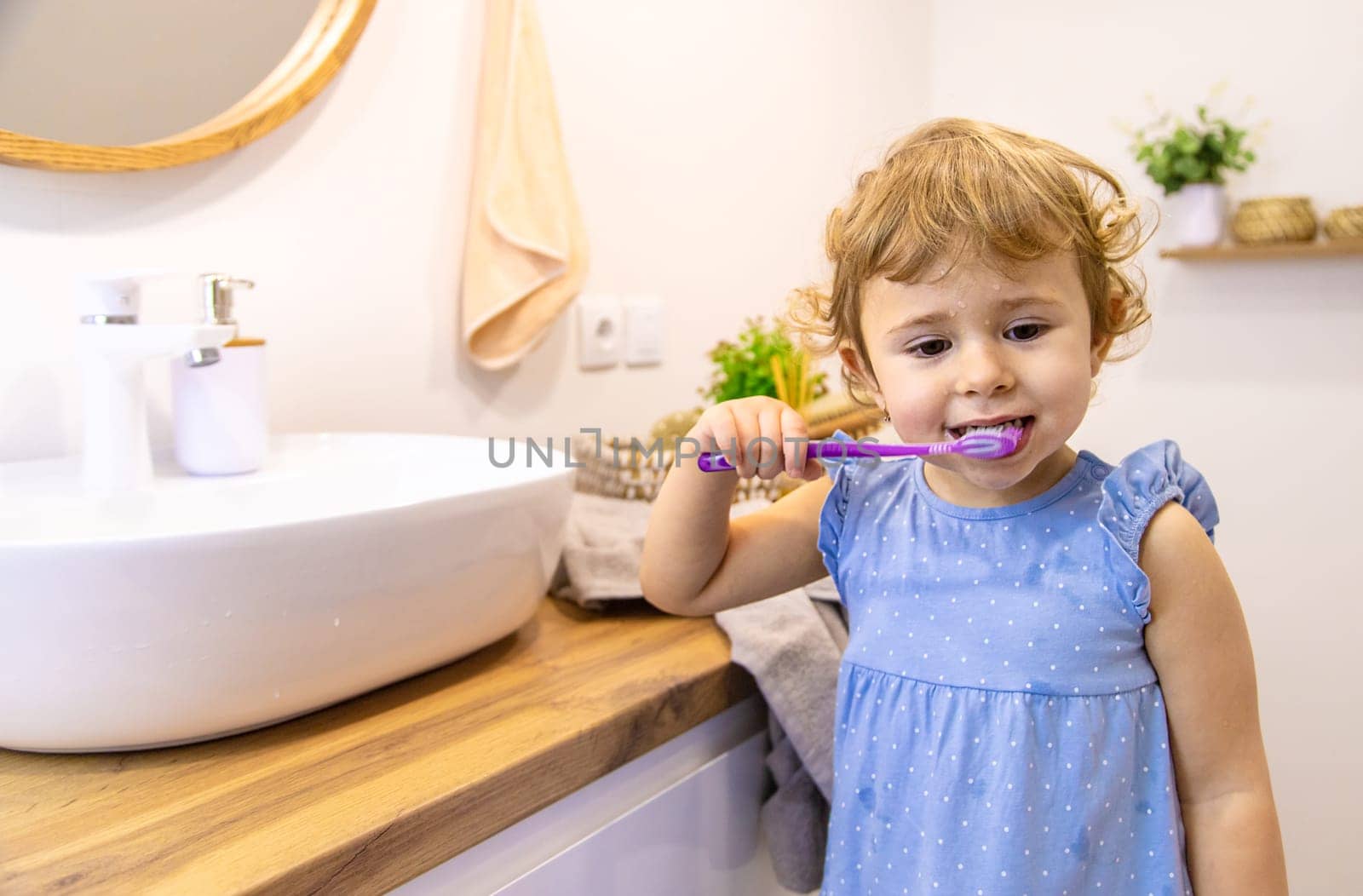 The child brushes his teeth in the bathroom. Selective focus. Nature.
