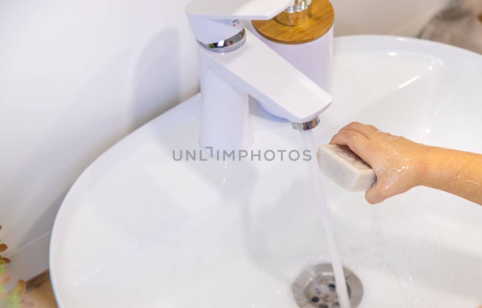 The child washes his hands with soap. Selective focus. Kid.