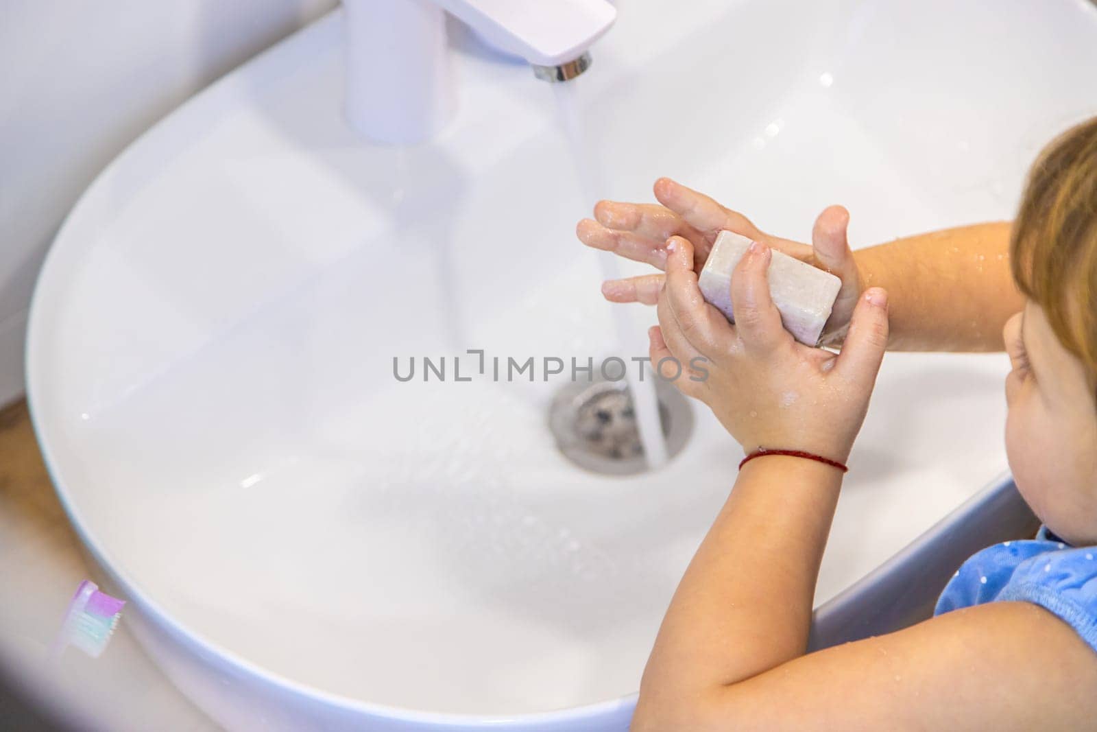 The child washes his hands with soap. Selective focus. Kid.