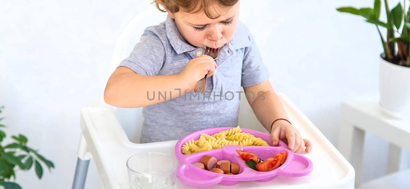 The child eats pasta and vegetables. Selective focus. Kid.