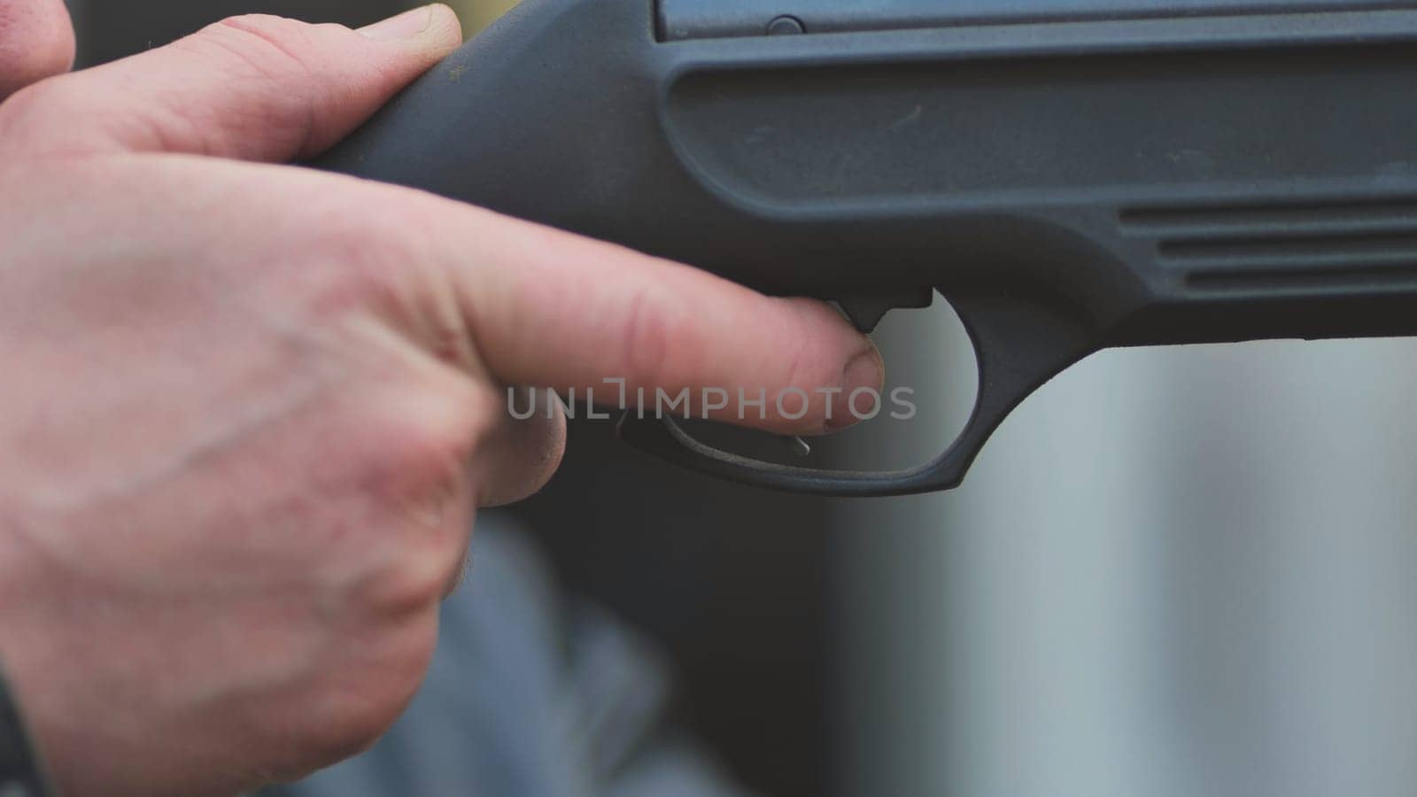 A man firing an air gun. Close-up of her hands