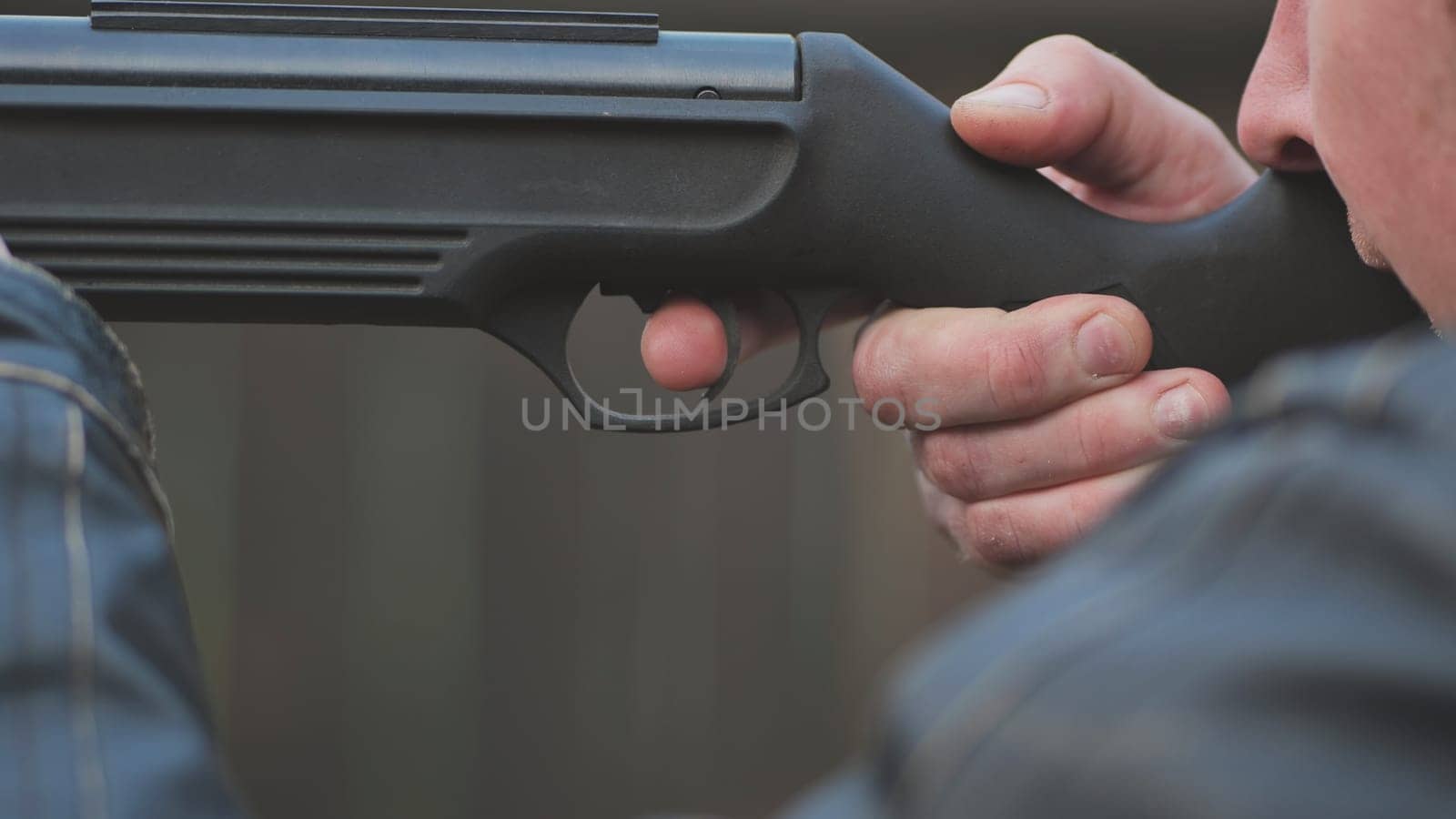 A man firing an air gun. Close-up of her hands