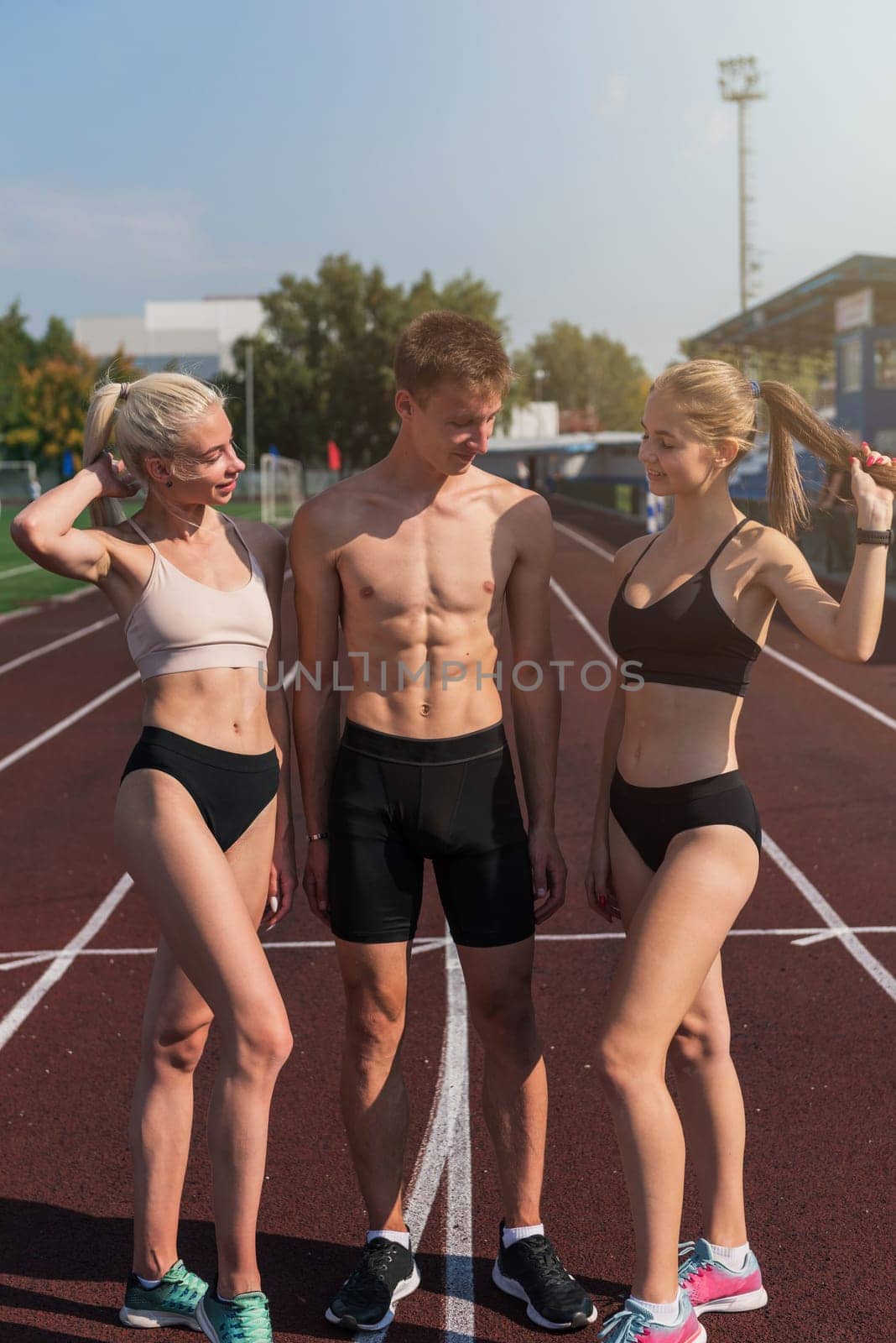 Group of athlete young women and man runnner at the stadium outdoors