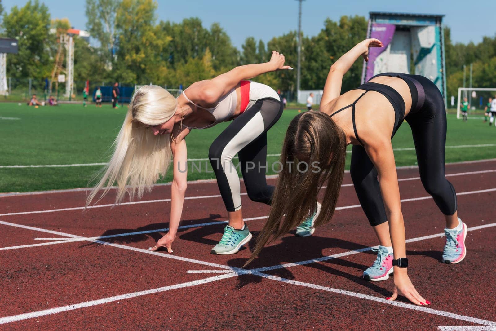 Two athlete young woman runnner at the stadium by rusak