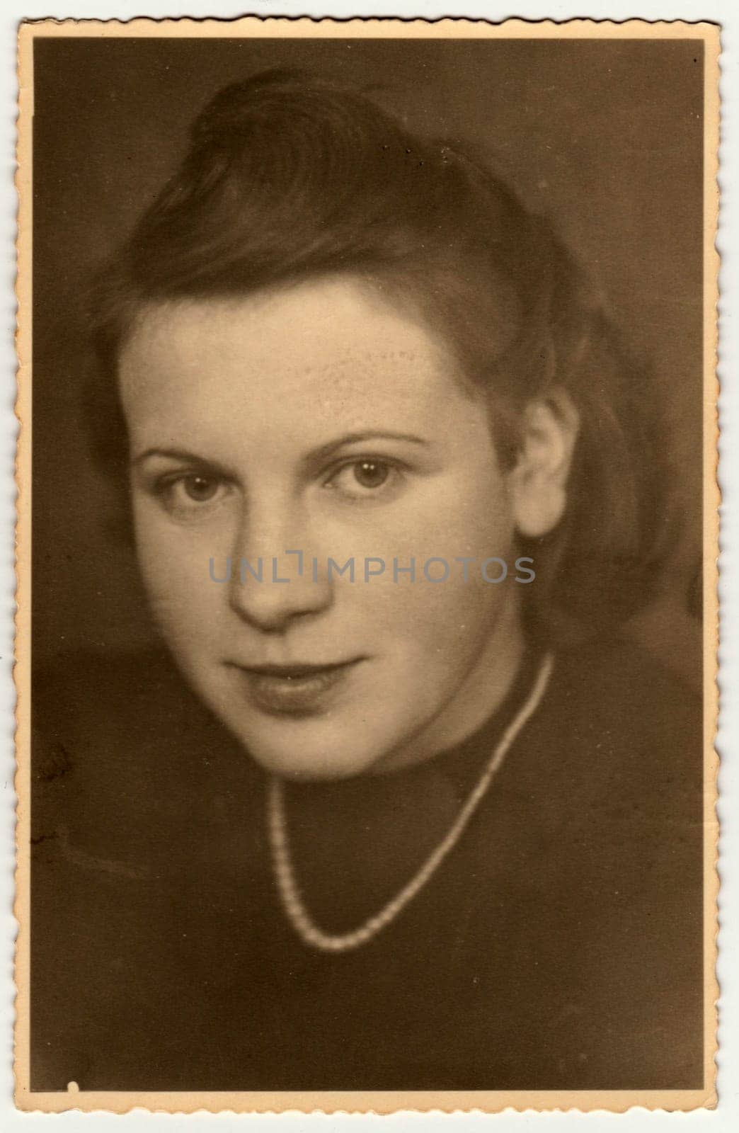 OBERAMMERGAU, GERMANY - CIRCA 1940s: Vintage photo shows the portrait of a young girl. Retro black and white studio photography.