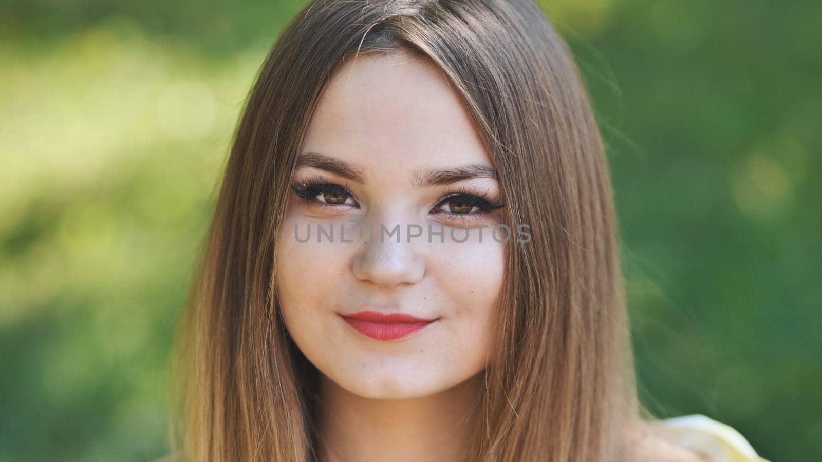 Portrait of a young girl in a park. Close-up of her face