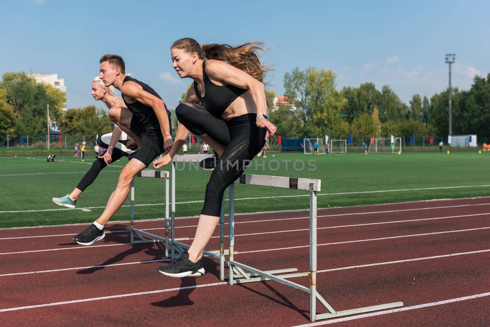 Two athlete woman and man runnner running hurdles by rusak