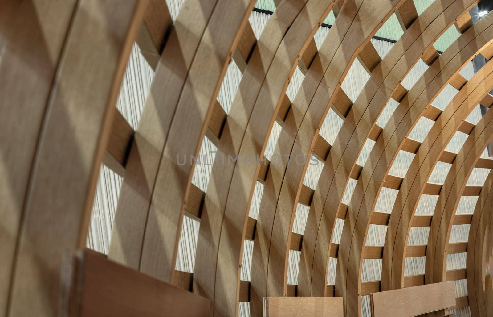 The Interior of Curved Diagonal Lines are made of the Wooden Composite with the Facade Design Architecture. Structure Perspective View of Softwood Curved Pergola. Sawn Arches, Design Architecture, Selective focus.
